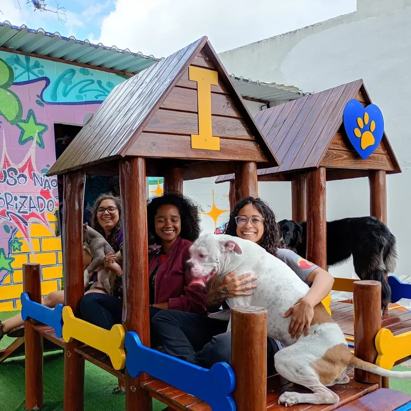 Monitoras da Fases abraçando os cães no parque