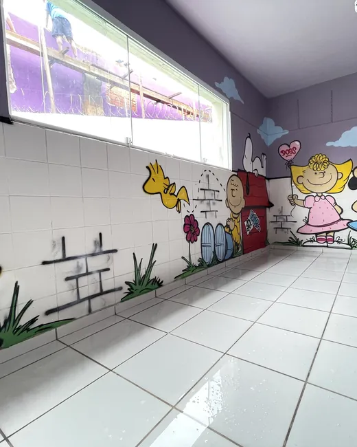 Quarto amplo e iluminado, com janela alta e mural colorido